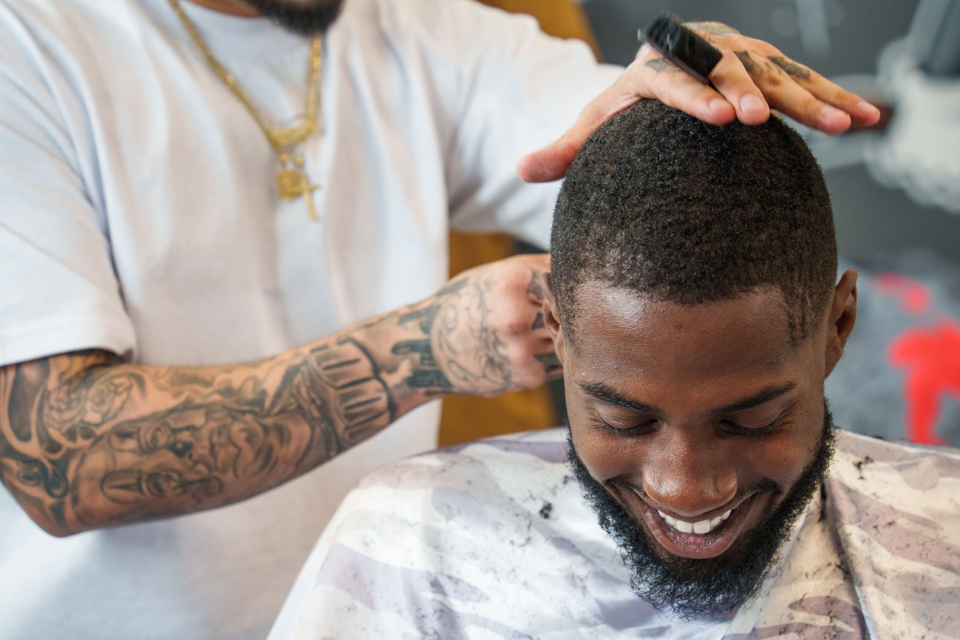 Young African American Man Receiving Fade Haircut from Mexican Barber in an Old Fashioned Barbershop with Electric Clippers