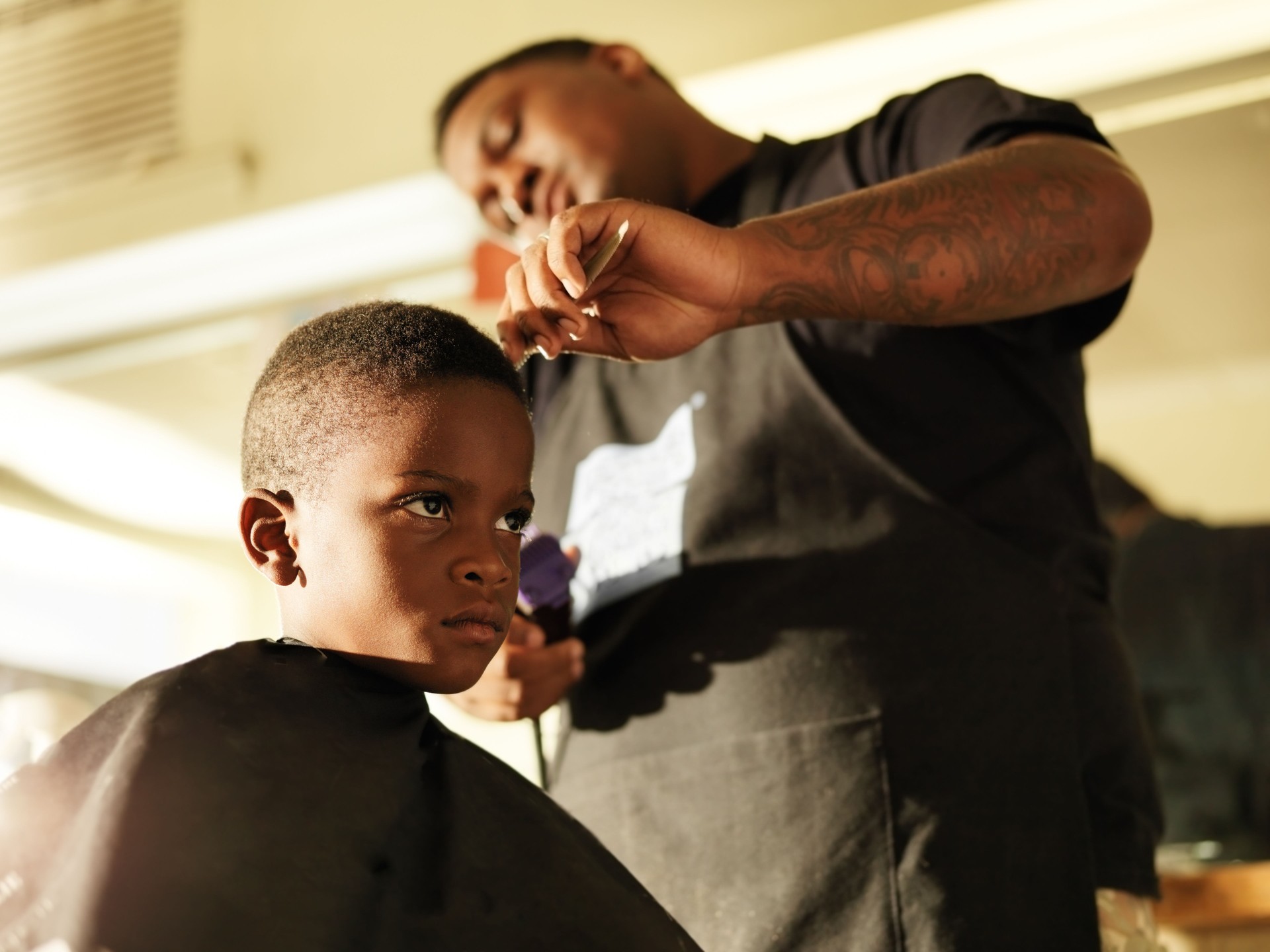 Photo of a boy getting his hair cut by a barber